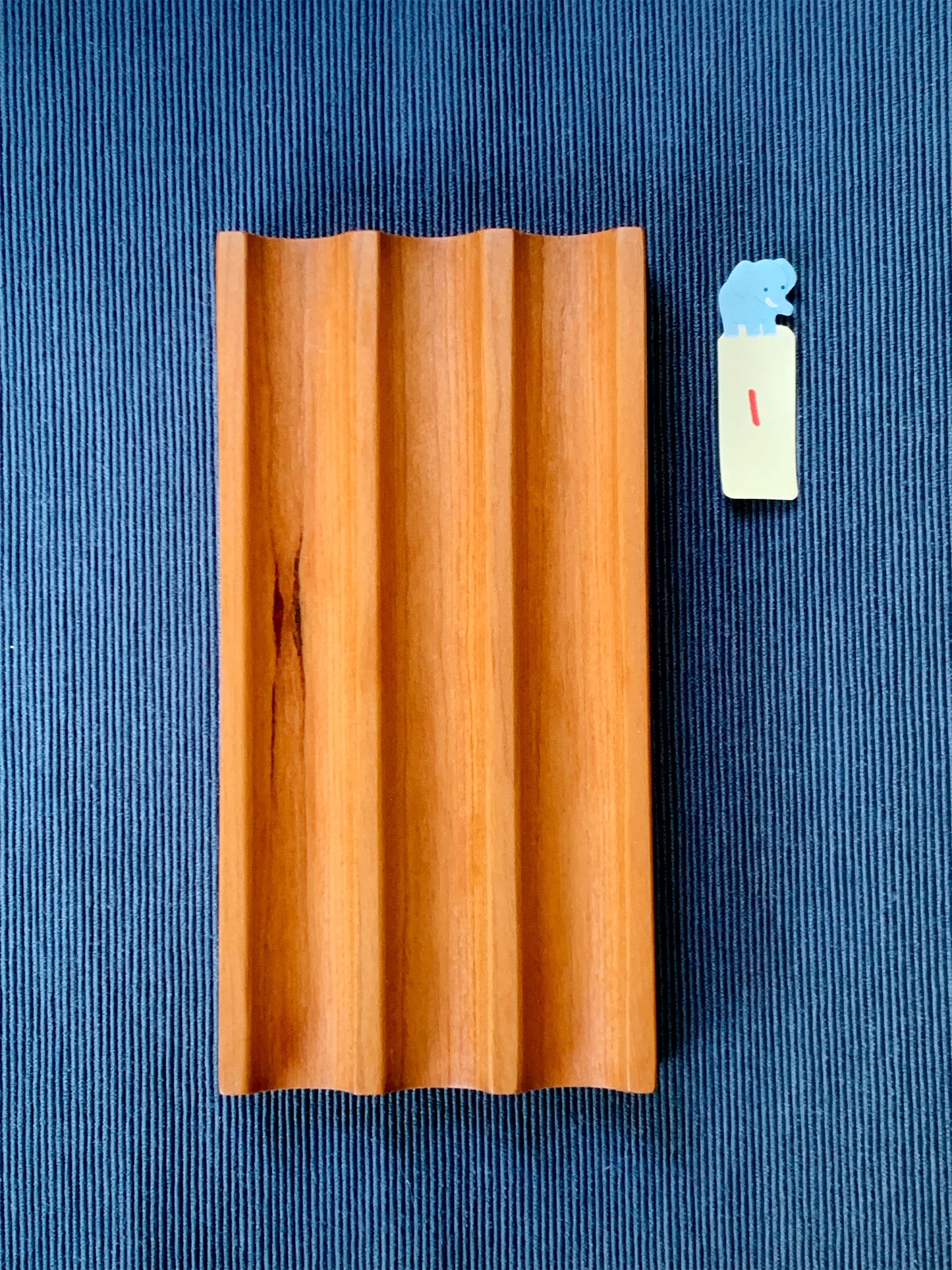 Elegant Kaze cherry pen tray with three smooth slots – shown on a deep blue textured backdrop. Tray #1