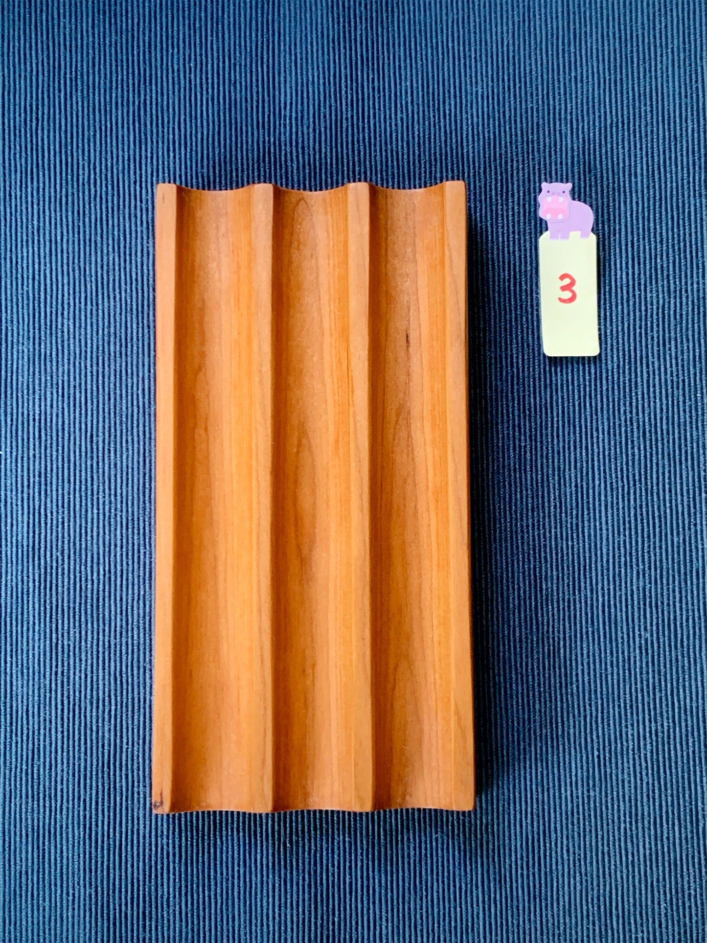 Elegant Kaze cherry pen tray with three smooth slots – shown on a deep blue textured backdrop. Tray #3
