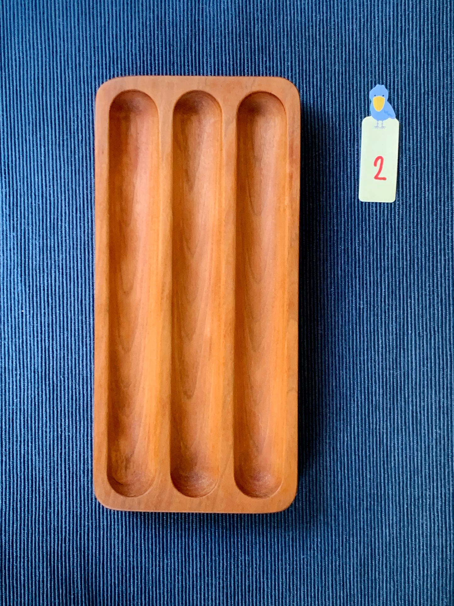 Elegant Shizuku cherry pen tray with three smooth slots – shown on a deep blue textured backdrop. Tray #2