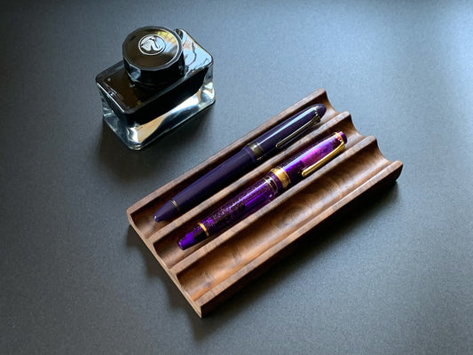 Premium Kaze figured walnut pen tray - 3 slots with fountain pen and ink bottle on a dark desktop
