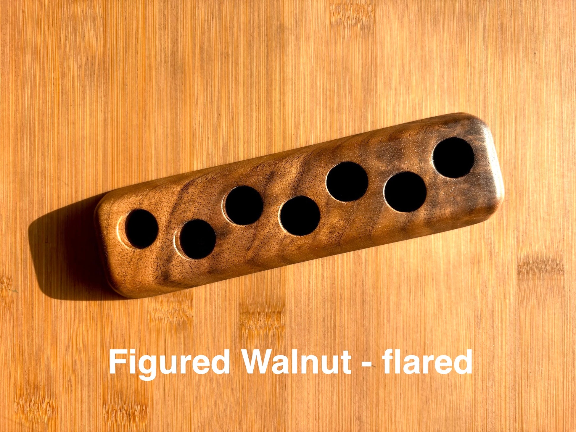 Figured walnut ink sample vial holder with flared base, showcasing dark swirling grain patterns