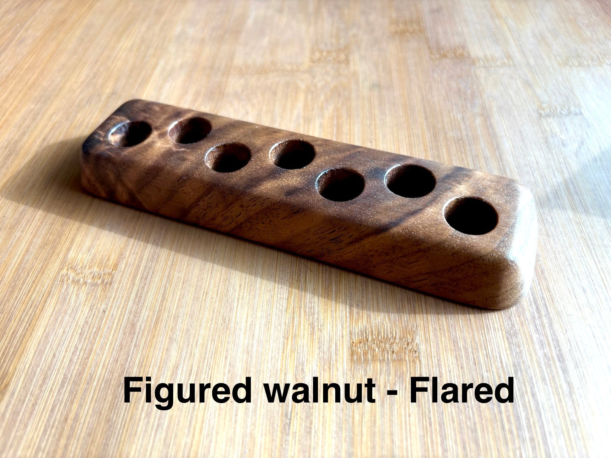 Flared-base figured walnut ink sample vial holder highlighting rich, wavy grain