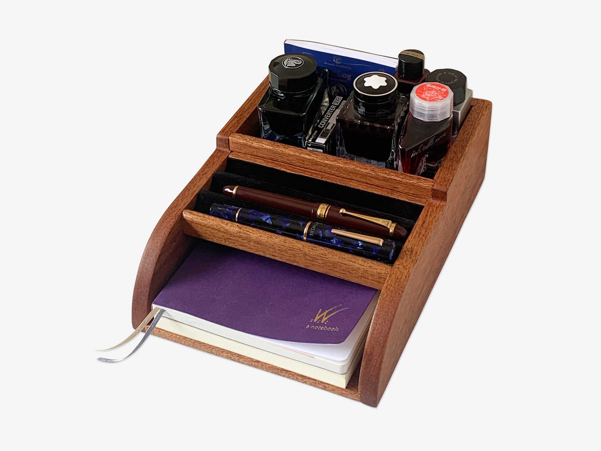 Handcrafted mahogany desk organizer holding fountain pens, ink bottles, and notebooks