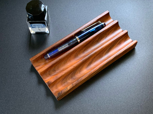 Premium Kaze Rosewood pen tray with fountain pen and ink bottle on a dark desktop